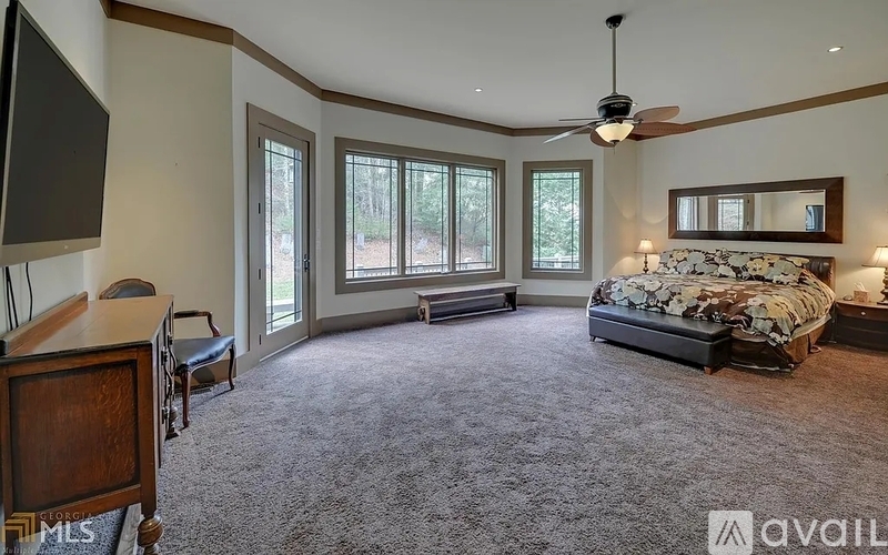 A bedroom with a bed, dresser, and a ceiling fan.