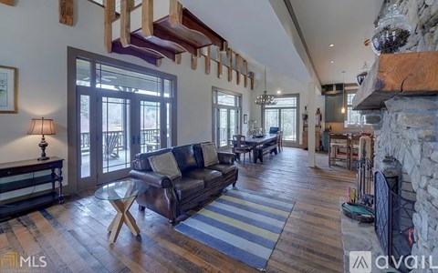 A living room with a black couch and a wooden coffee table.