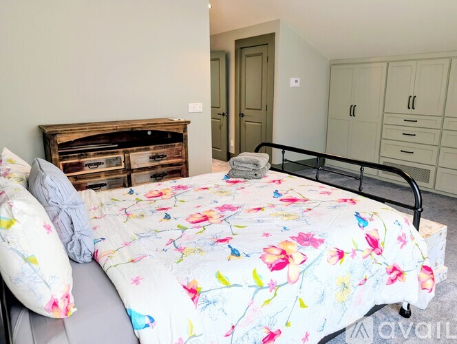 A bedroom with a bed, a wooden headboard, and a metal bed frame.