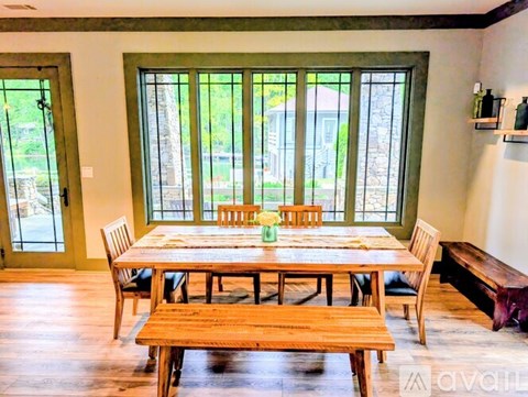 A dining room with a wooden table and chairs.