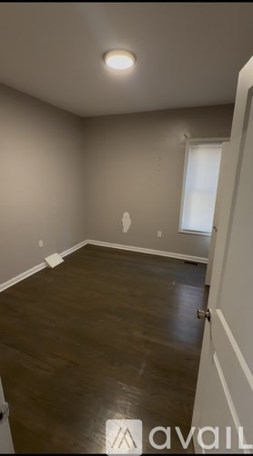 A room with wooden flooring and a white door.