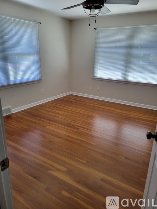 A room with wooden flooring and a ceiling fan.