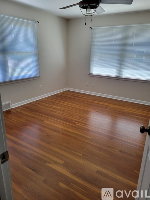 A room with wooden flooring and a ceiling fan.