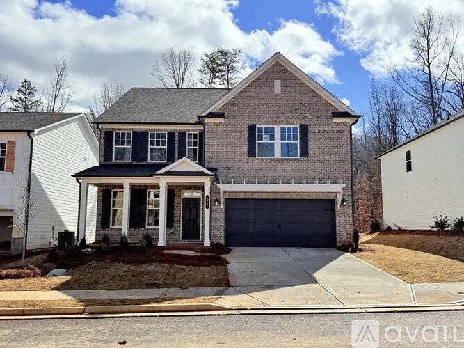 A two-story house with a garage is available for sale.