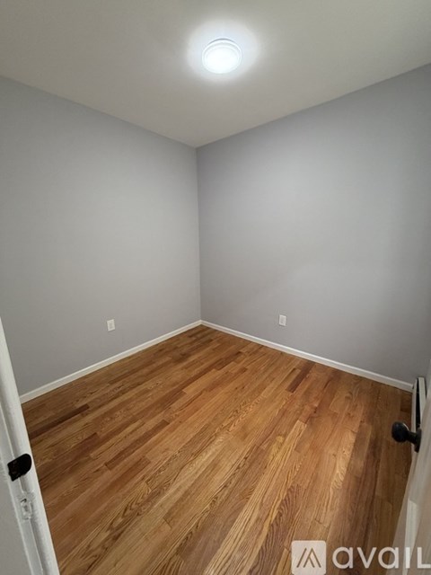 A room with wooden flooring and a white door.
