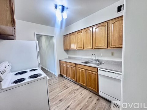 A kitchen with wooden cabinets and a white stove top oven.