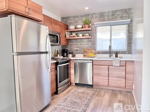 A kitchen with a stainless steel refrigerator and wooden cabinets.