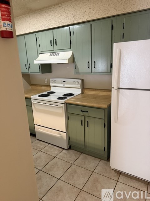 A kitchen with a white fridge, white stove and white oven.