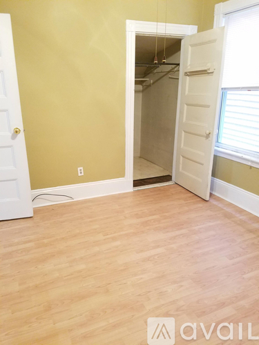 A room with a white door and a wooden floor.