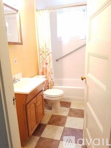 A bathroom with a toilet, sink, and a checkered floor.