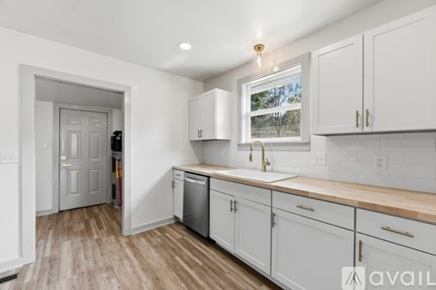 A kitchen with white cabinets and a wooden countertop.