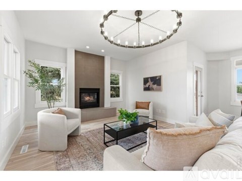 A modern living room with a fireplace and a chandelier.