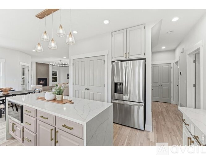 A modern kitchen with a marble countertop and stainless steel appliances.
