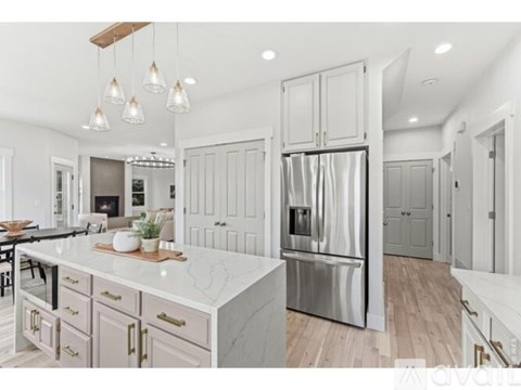 A modern kitchen with a marble countertop and stainless steel appliances.