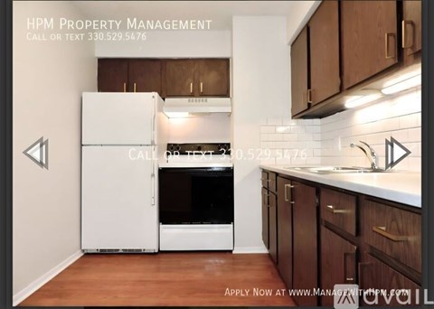 A kitchen with a white refrigerator and wooden cabinets.