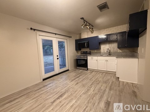 A kitchen with a black oven and white cabinets.