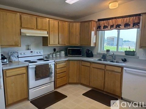 A kitchen with wooden cabinets and a white stove top oven.