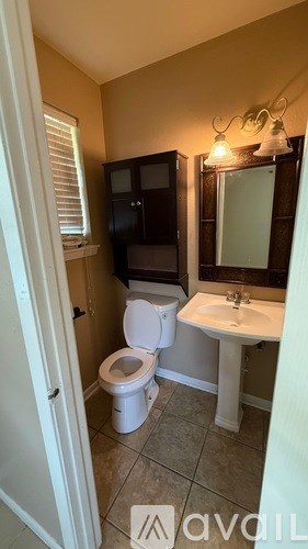 A bathroom with a toilet, sink, and medicine cabinet.