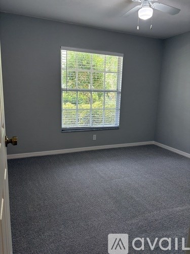A room with grey walls and a window with blinds.