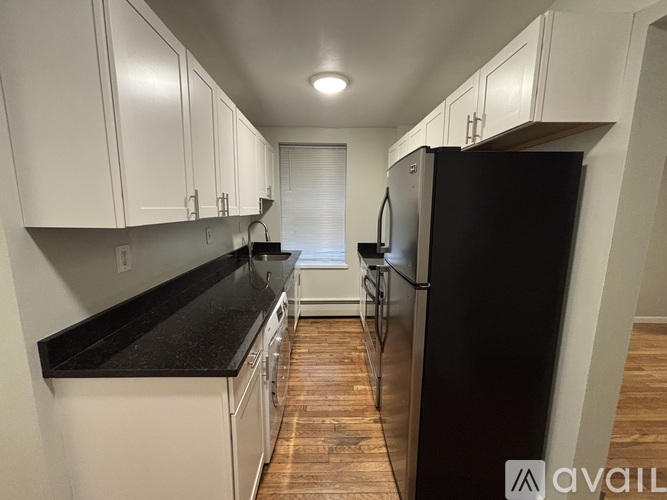 A kitchen with black countertops and white cabinets.