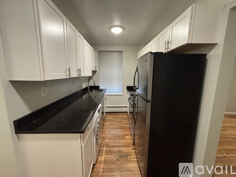 A kitchen with black countertops and white cabinets.
