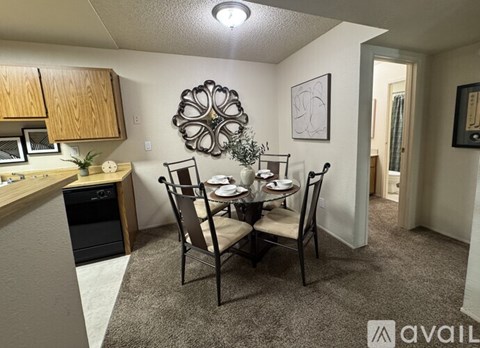 A dining area with a table set for two and a kitchen area with a microwave and oven.