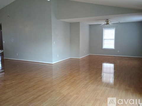 A room with wooden flooring and a window.