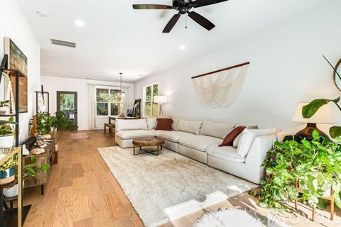 A living room with a white couch and a rug.
