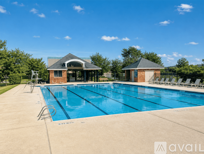 A large outdoor swimming pool with a pavilion and lounge chairs.
