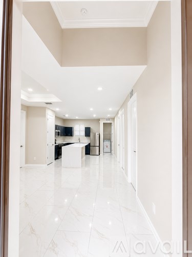A long hallway with white marble floors and white walls.