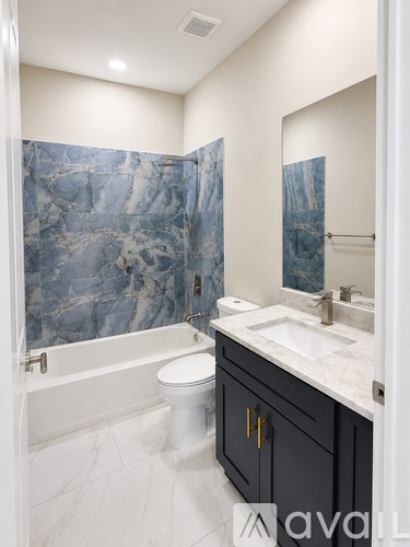 A bathroom with a marble shower and a white toilet.