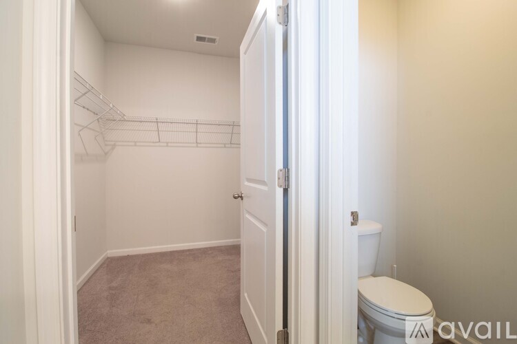 A small, empty bedroom with a toilet in the corner.