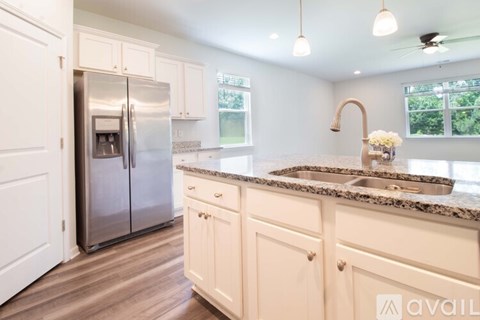 A kitchen with white cabinets and a granite countertop.