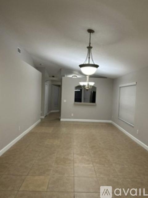 A room with a tiled floor and a hanging light fixture.