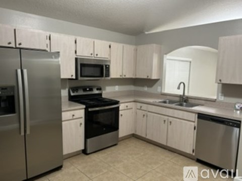A kitchen with white cabinets and stainless steel appliances.