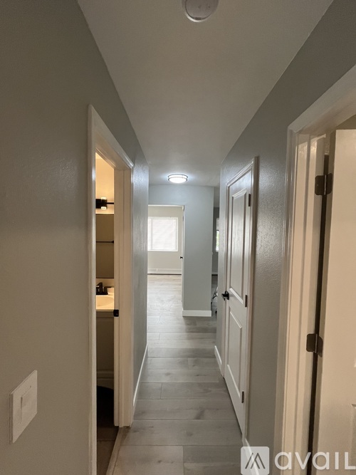 A long hallway with doors on both sides and a light on the ceiling.