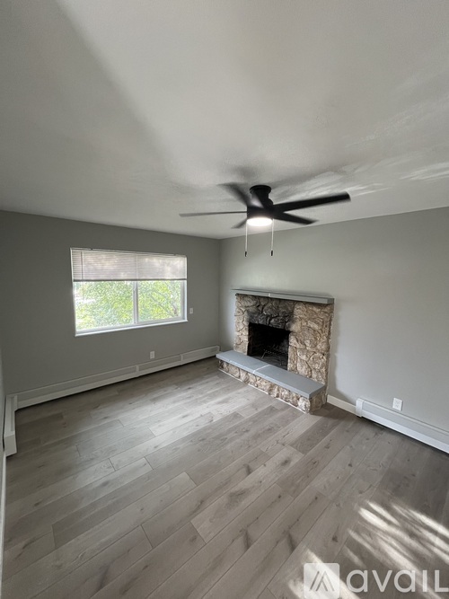 A room with a fireplace and a ceiling fan.