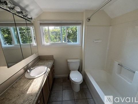 A bathroom with a toilet, sink, and bathtub.