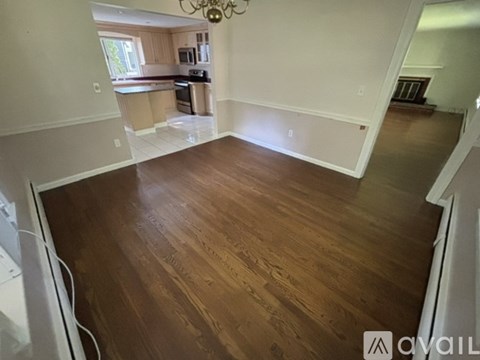 A room with wooden flooring and white walls.