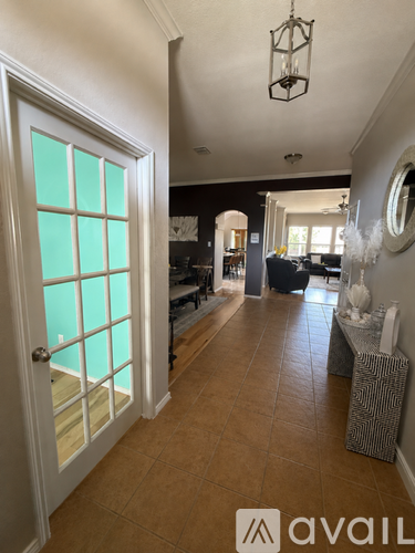 A hallway with a white door and a chandelier.