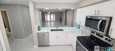 A kitchen with white cabinets and a black stove top oven.