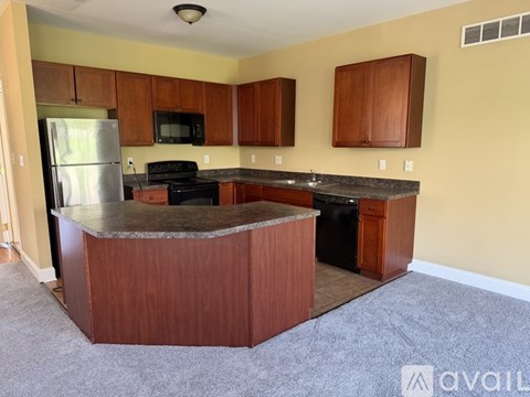 A kitchen with wooden cabinets and a granite countertop.