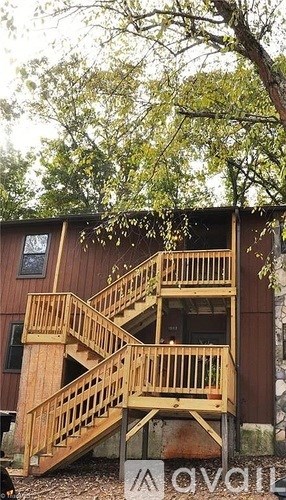 A wooden staircase with a railing is in front of a building.