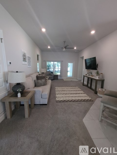 A living room with a grey carpet and furniture.