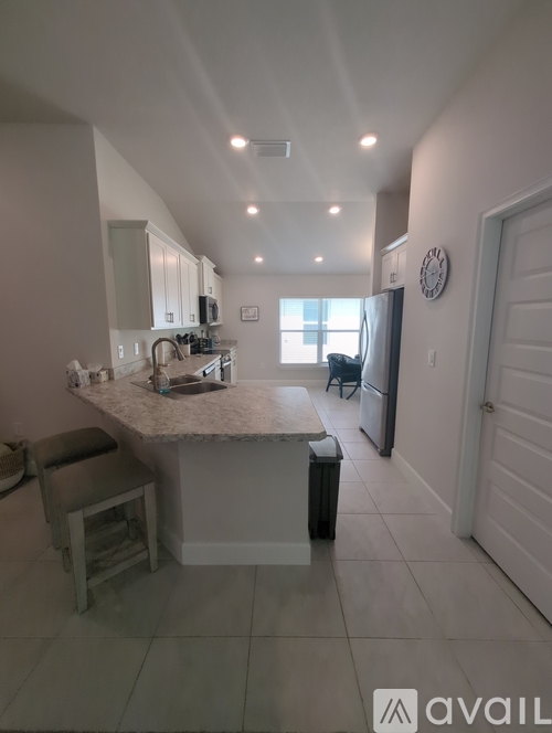 A kitchen with a counter and a bar stool.
