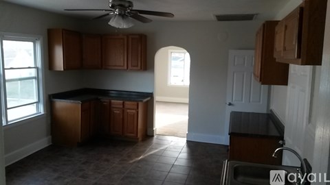 A kitchen with brown cabinets and a black countertop.