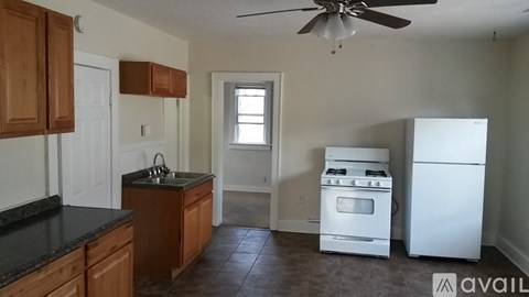 A kitchen with wooden cabinets and a black countertop.
