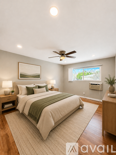 A bedroom with a bed, a ceiling fan, and a window.