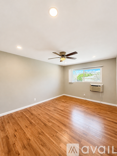 A room with wooden flooring and a ceiling fan.