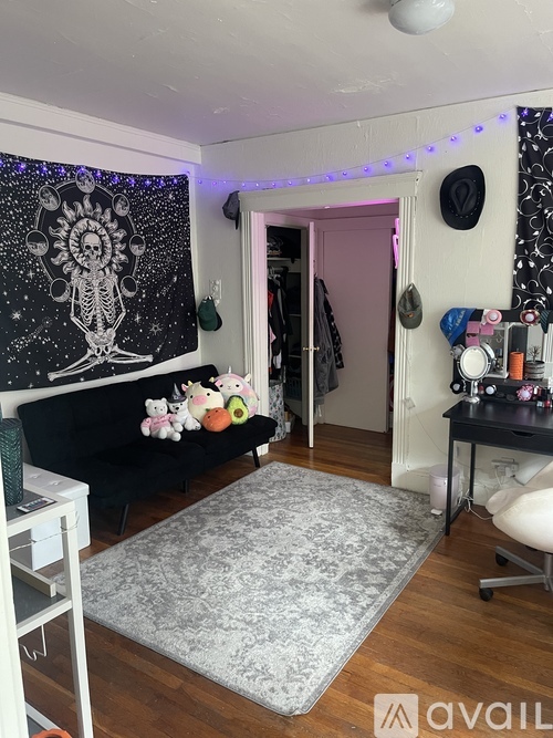 A room with a skeleton tapestry on the wall and a grey rug on the floor.
